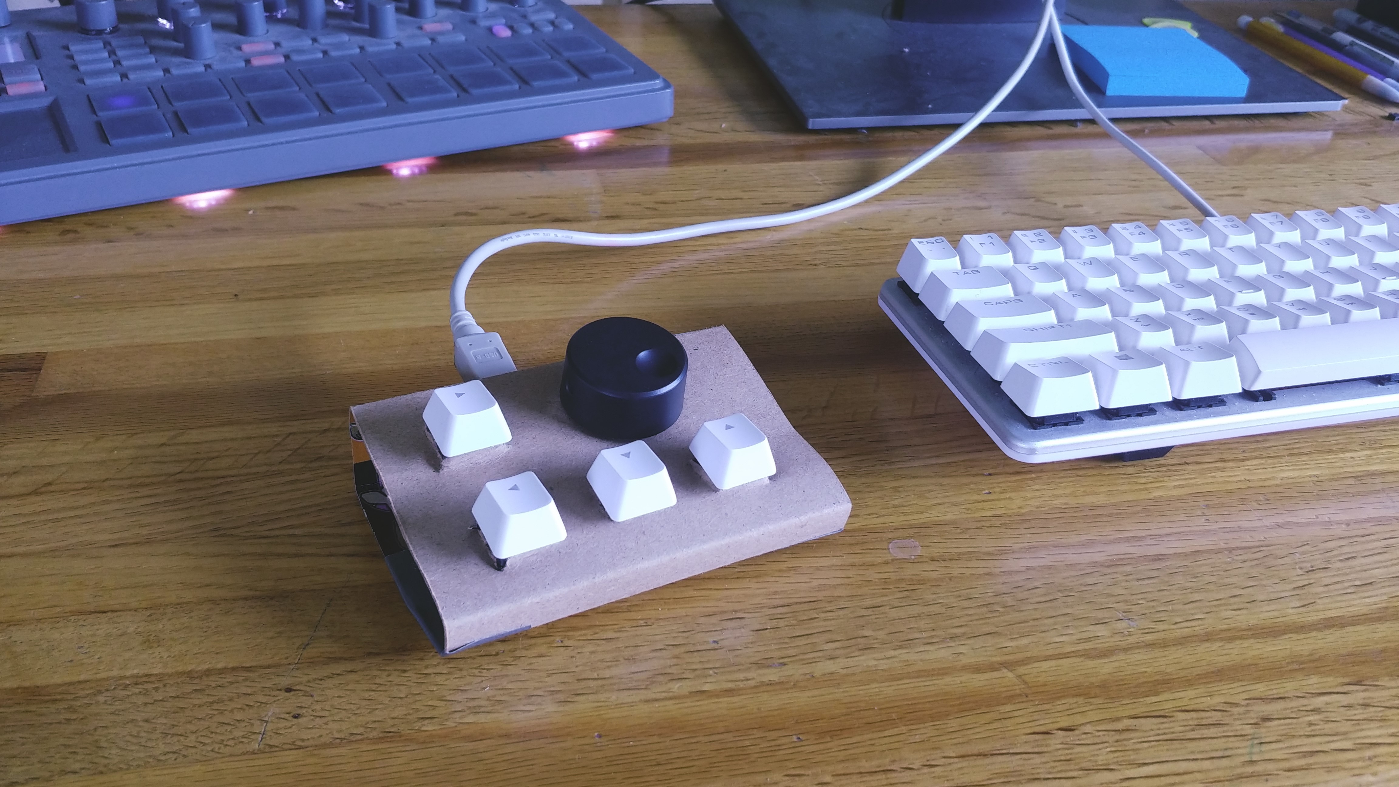A small, sloped, desktop controller with four keyswitches and a large knob.